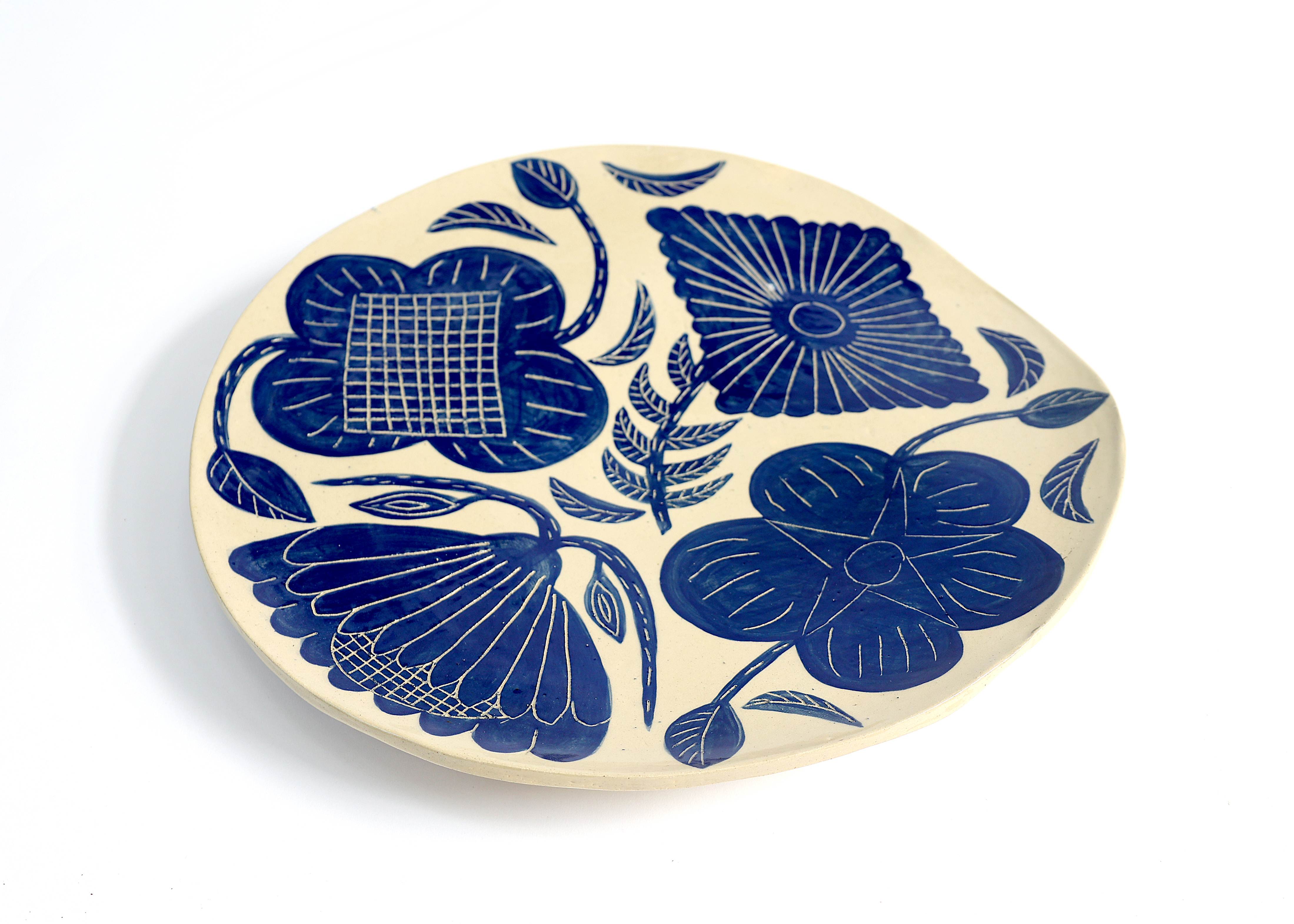 Large oval ceramic platter with intricate blue botanical patterns featuring detailed floral motifs with crosshatch and linear details on cream background