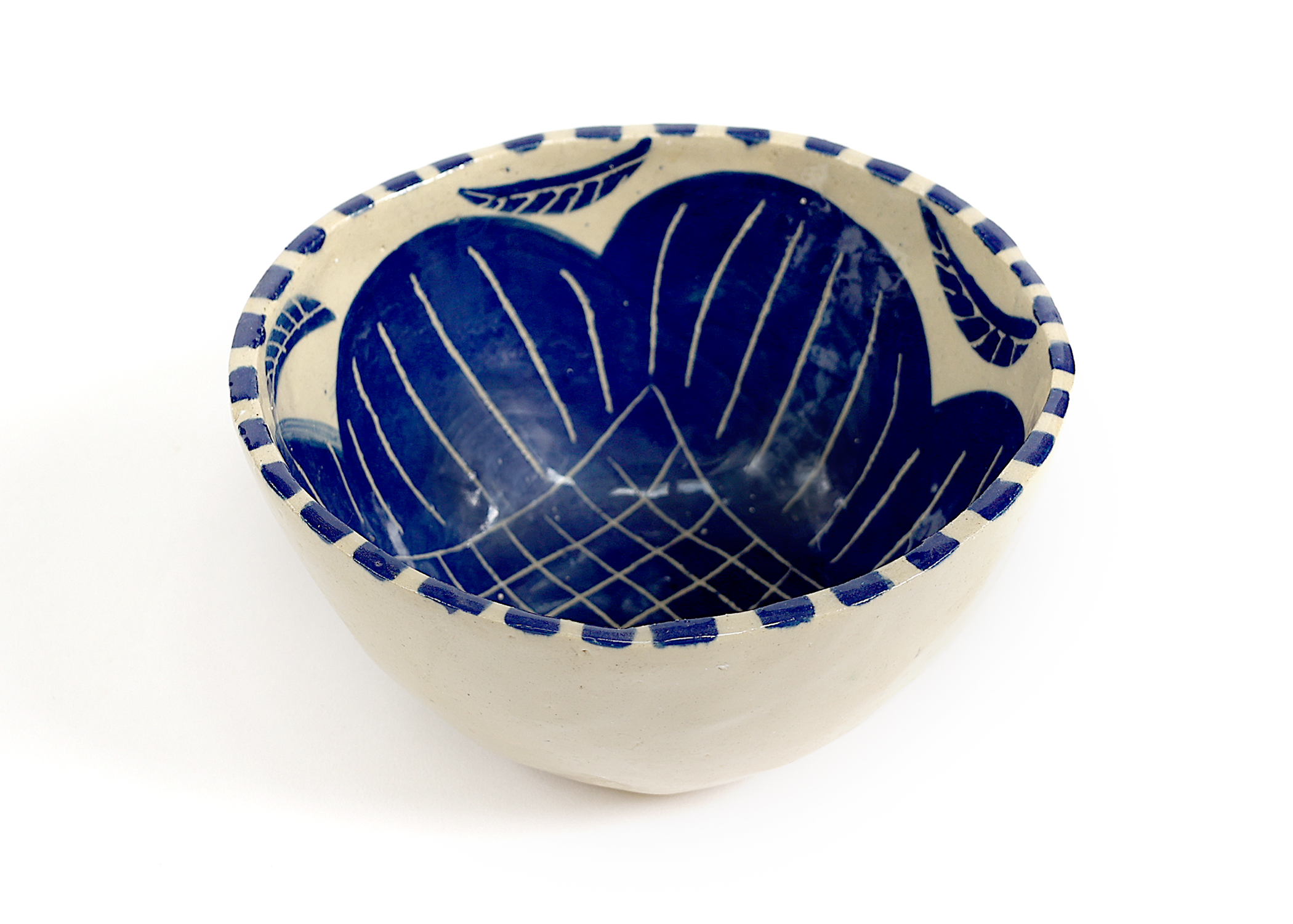 Ceramic bowl with deep blue interior featuring crosshatch grid patterns and decorative blue and white striped rim
