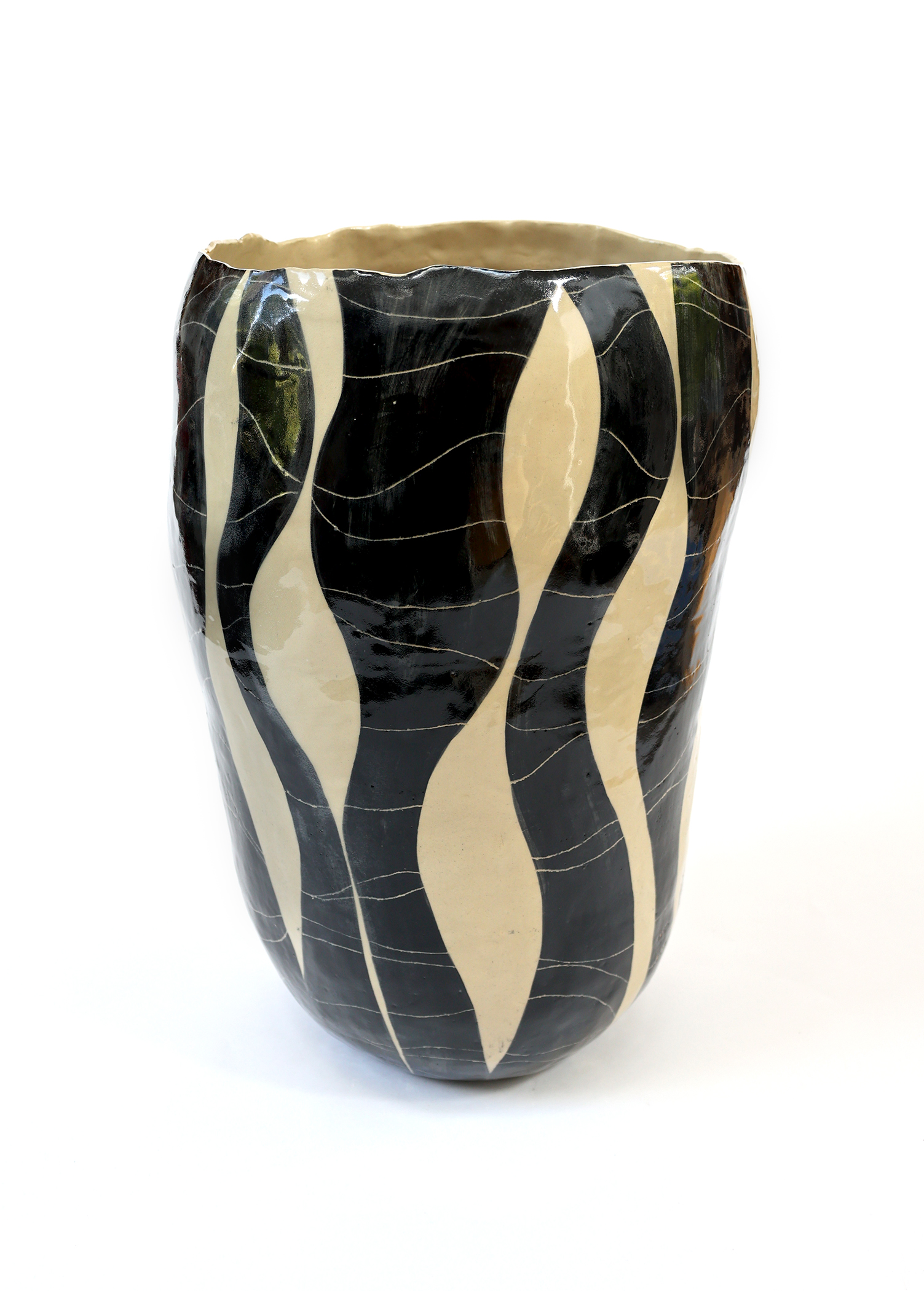 Tall ceramic vessel with dramatic black and cream vertical striping pattern enhanced by crackle glaze texture creating organic surface interest